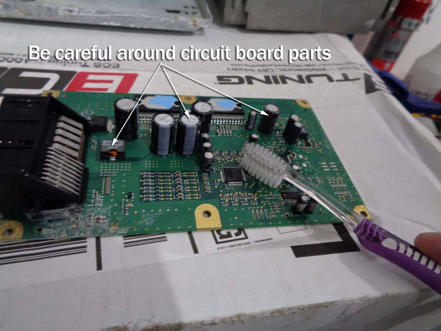 bmw e90 amplifier water damage repair - carefully clean the circuit board with toothbrush