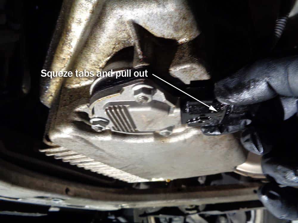 Squeeze the tabs on the oil sensor electrical connector and pull it loose.