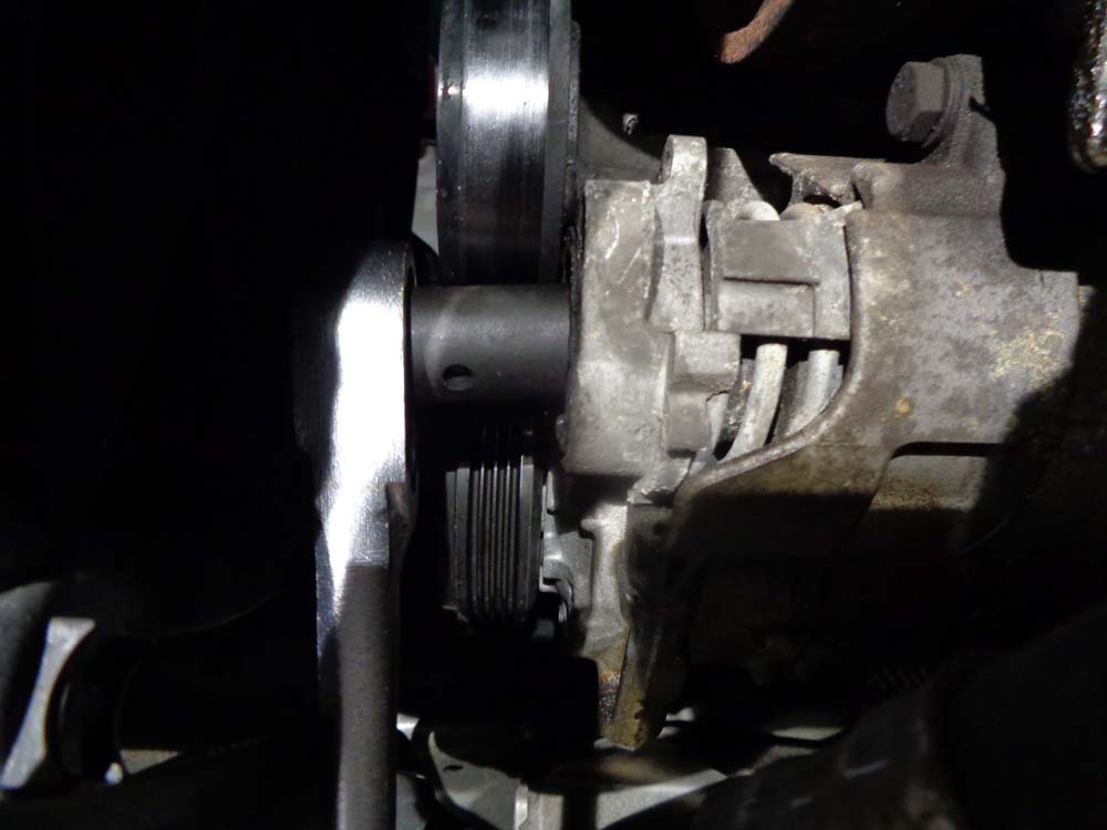 Remove the AC tensioner mounting bolt