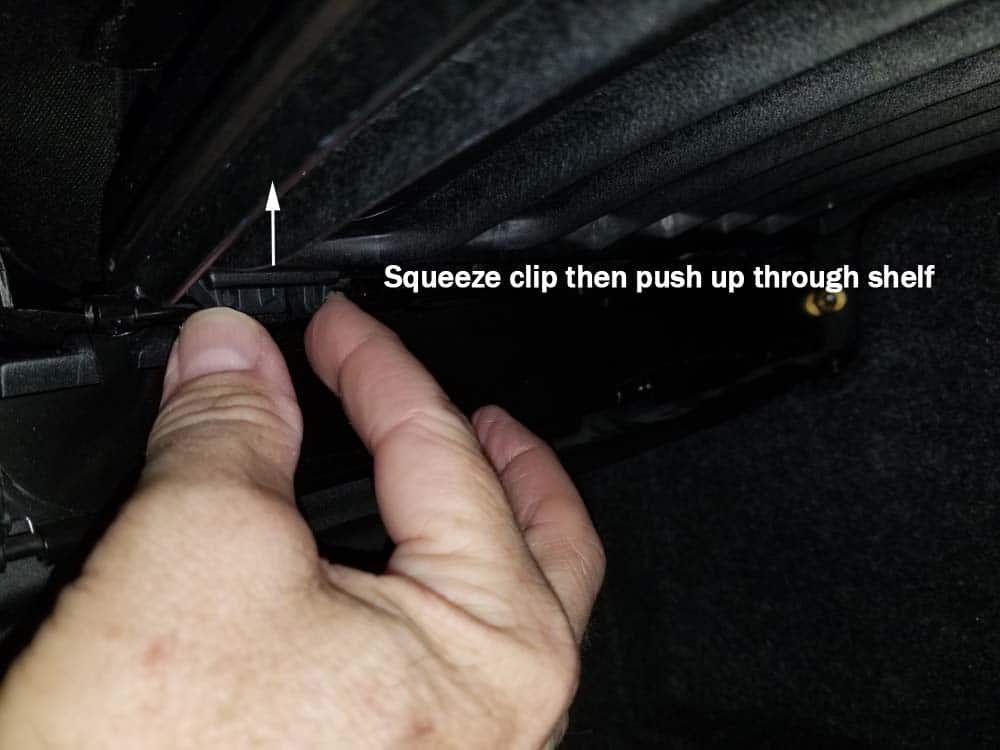 Squeeze the clips then push them up through the shelf