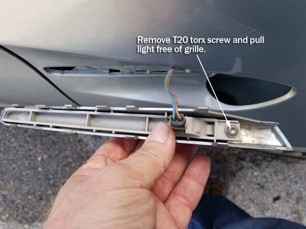 Remove the T20 torx screw on the back of the grille.