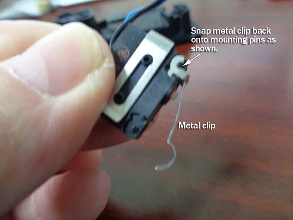 Snap the metal clip back on the mounting pins