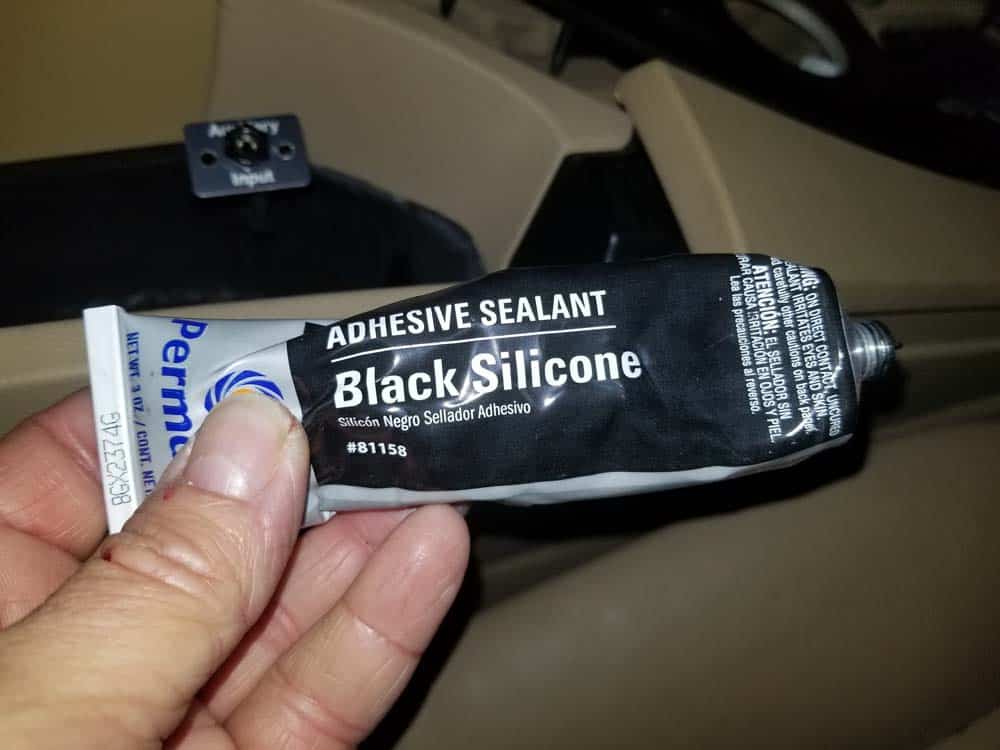 Use black silicone adhesive to glue the faceplate to the storage compartment