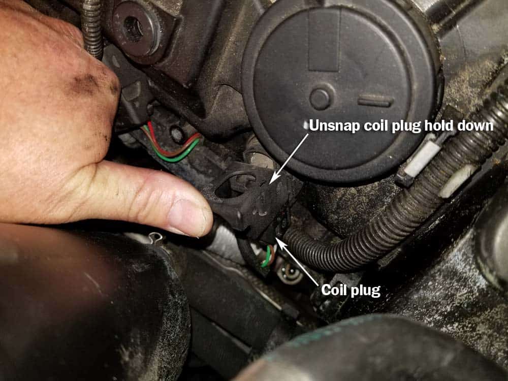BMW N62 engine tune up - Unsnap the coil's plastic locking mechanism.