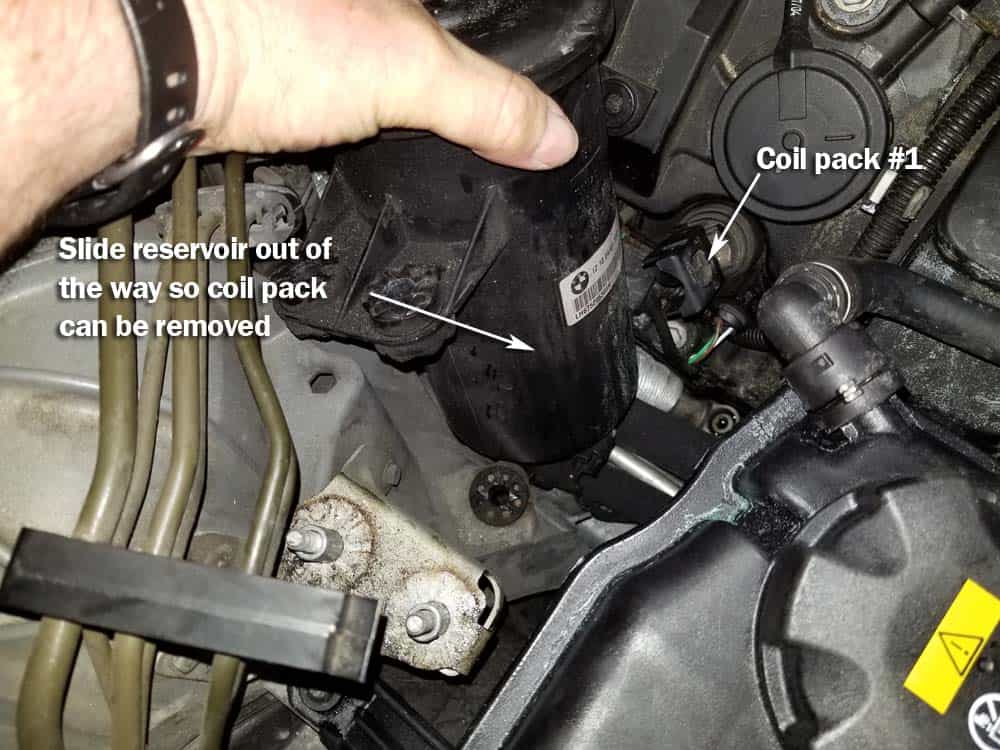 BMW N62 engine tune up - Slide the power steering reservoir out of the way
