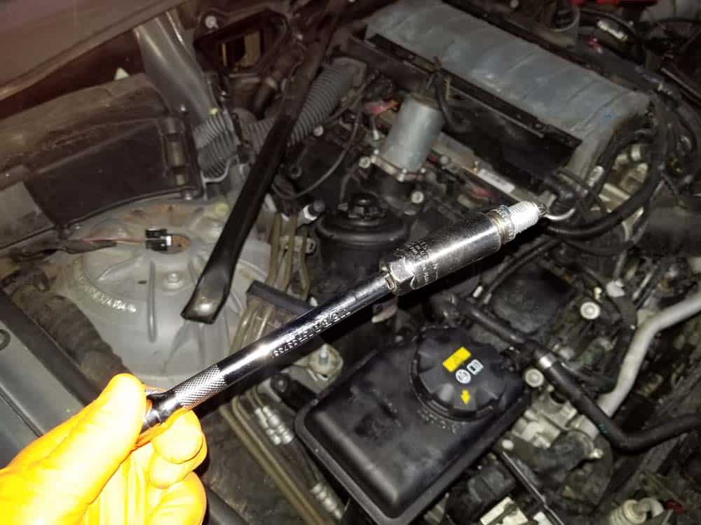 Install the new spark plug and hand tighten
