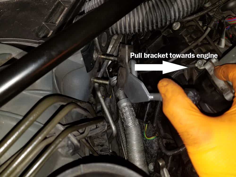 Remove the bracket nuts and pull the freon lines toward the engine