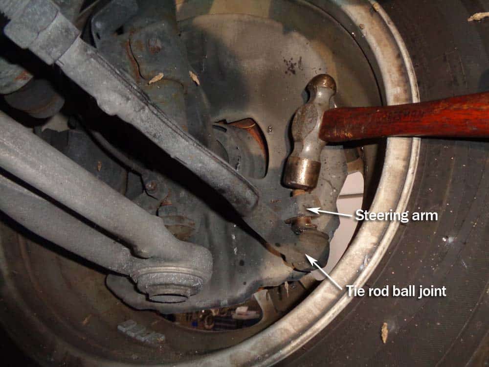 Use a hammer to remove the tie rod ball joint from the steering arm.