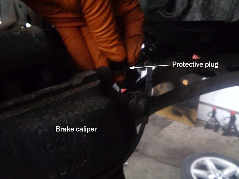 BMW E46 Brake Repair - remove the protective caps from the caliper bolts