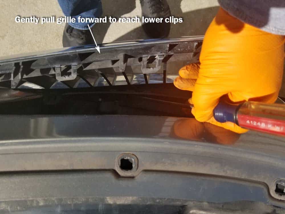 Pull the grille forward to access the lower plastic clips