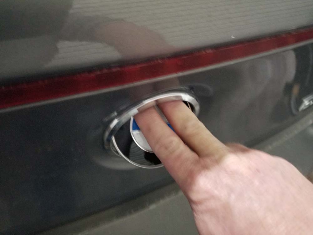 Use your fingers to press the emblem onto the handle