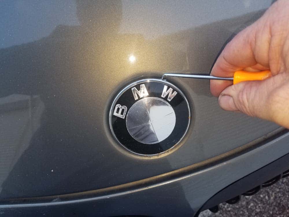 Use a metal pick or plastic trim tool to remove the old emblem