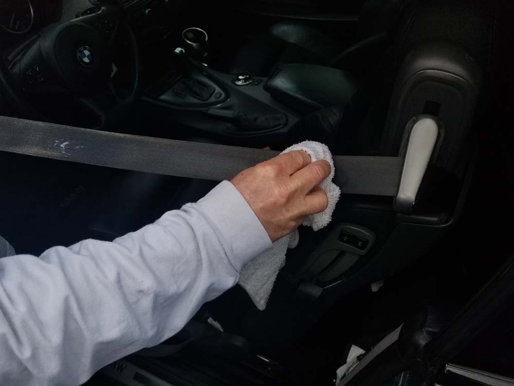 Wipe the seat belt down thoroughly with a clean rag