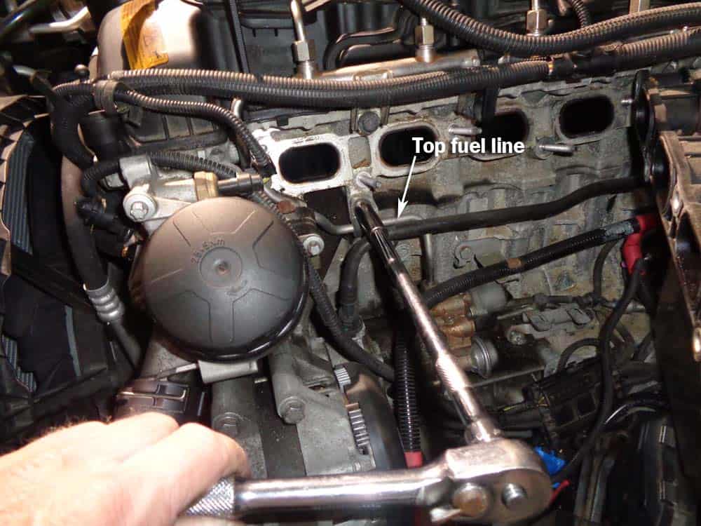 bmw high pressure fuel pump - Use a 10mm socket wrench to remove the top fuel line from the engine block.