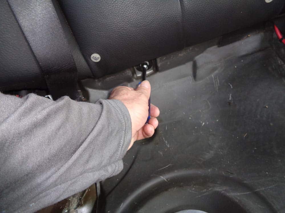Use a 10mm nut driver to remove the two nuts securing bottom of seat back to vehicle.