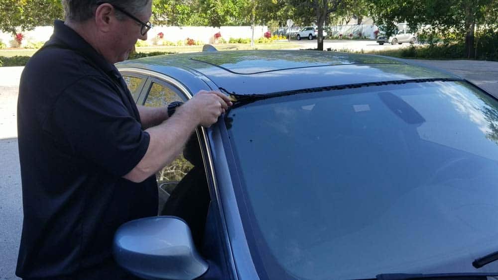 Use a trim tool to pry the end of the moulding out of the windshield