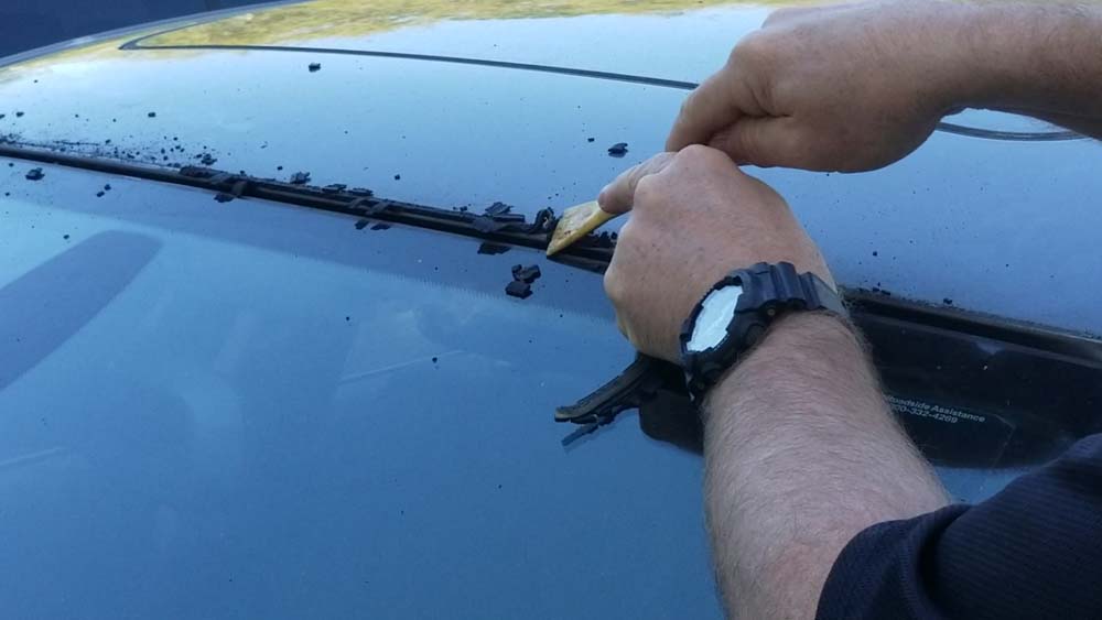 bmw windshield moulding replacement - scrape the old rubber from the roof of the vehicle