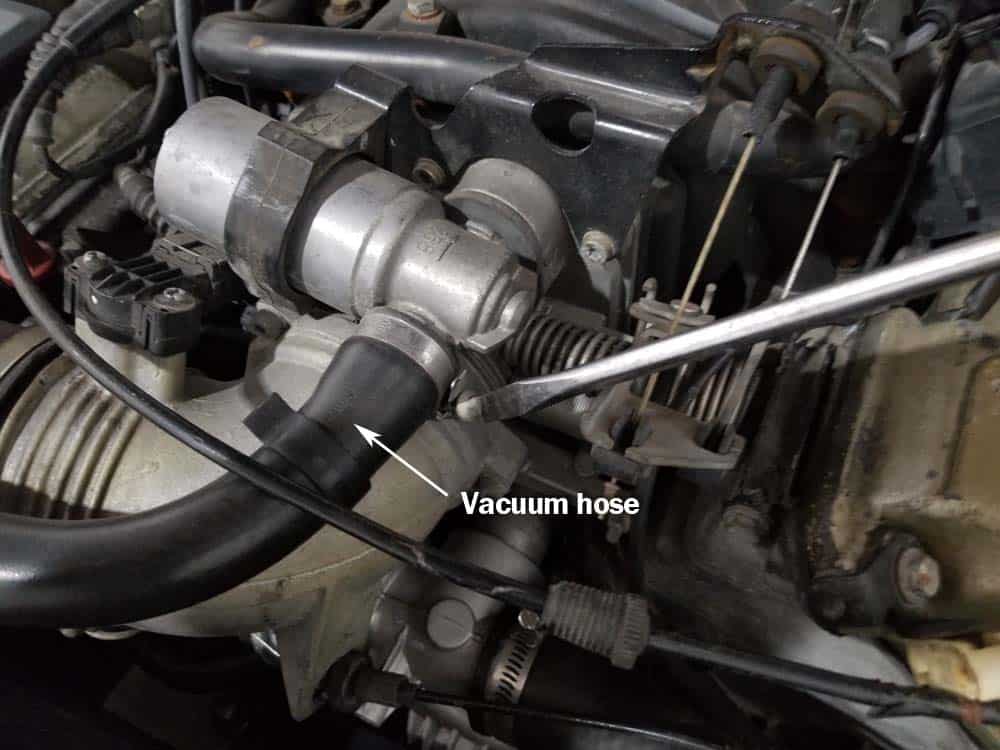 Loosen the vacuum hose clamp with a flat blade screwdriver