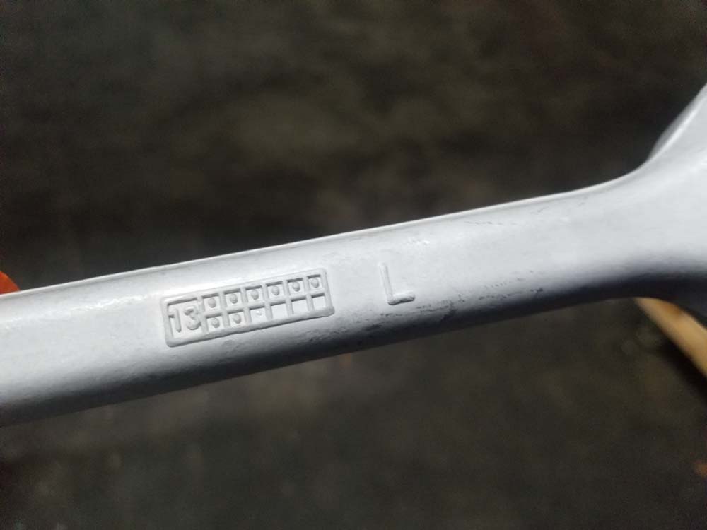 Embossed letter on lower control arm showing the correct side of the car