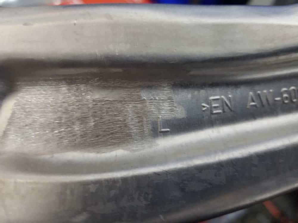 Embossed letter on tension strut showing the correct side of the car