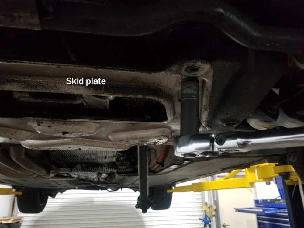 bmw e60 front axle shaft - Remove the six bolts securing the skid plate to the bottom of the vehicle.