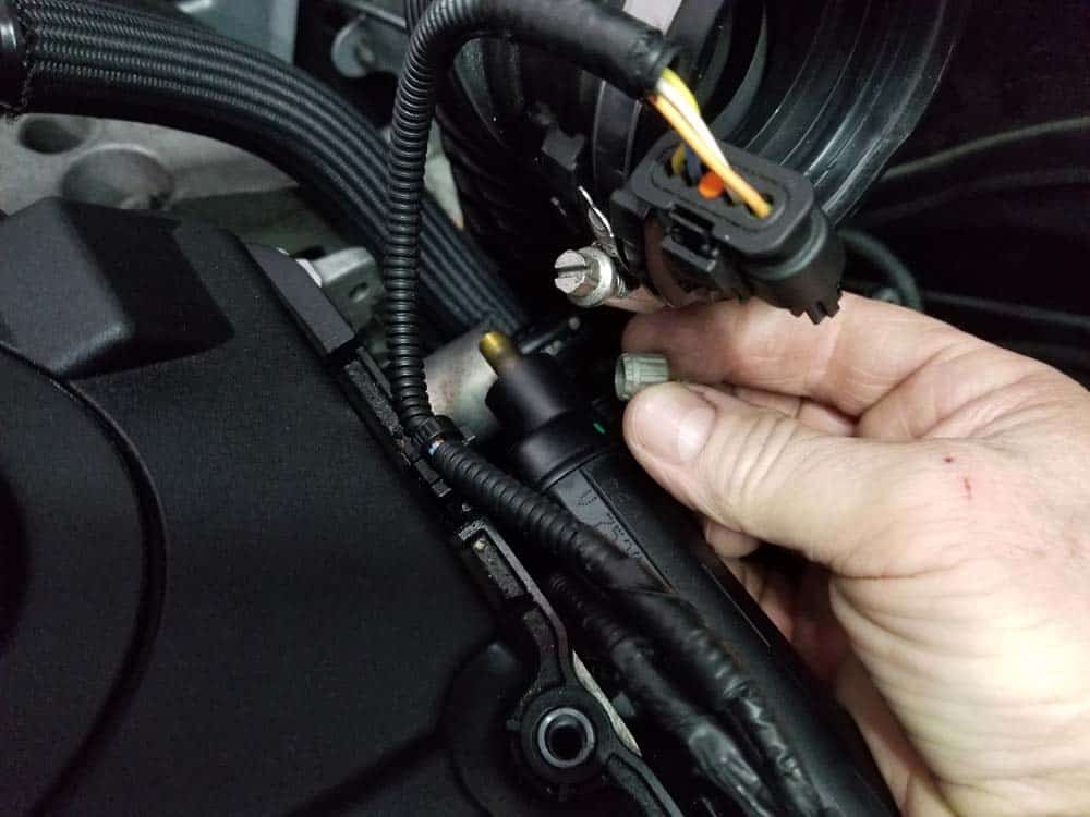 MINI R56 water pipe replacement - Remove the protective cap off of the fuel rail schrader valve