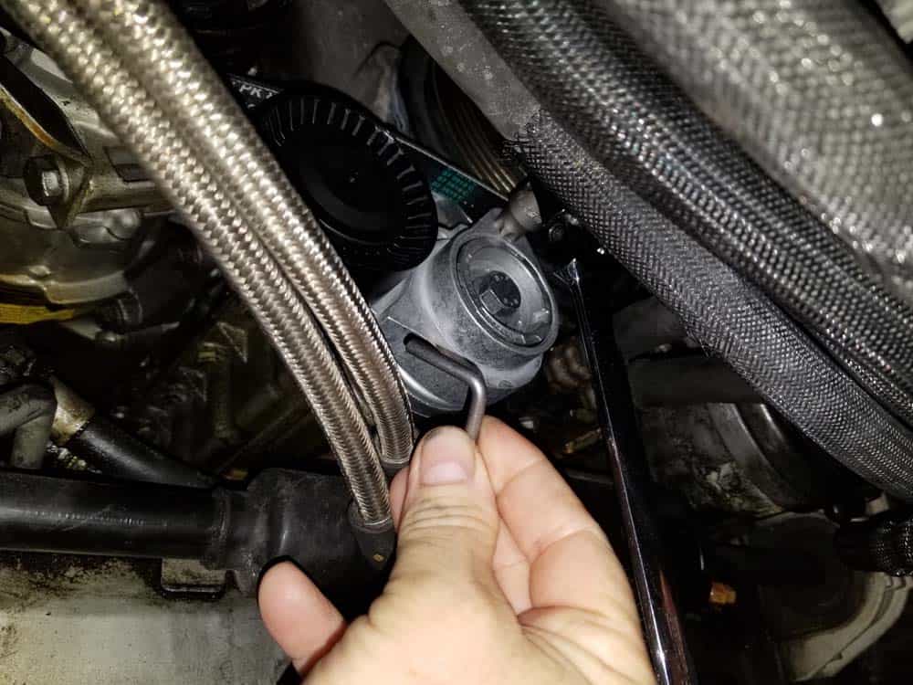 BMW N62 ac belt tensioner - Turn the tensioner counter-clockwise to retract the pulley and remove the locking pin.