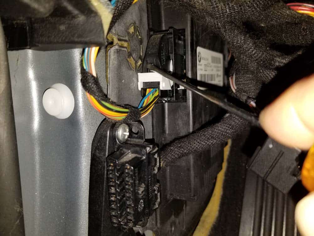 bmw footwell module - Release the locking tab on the rear wiring harness