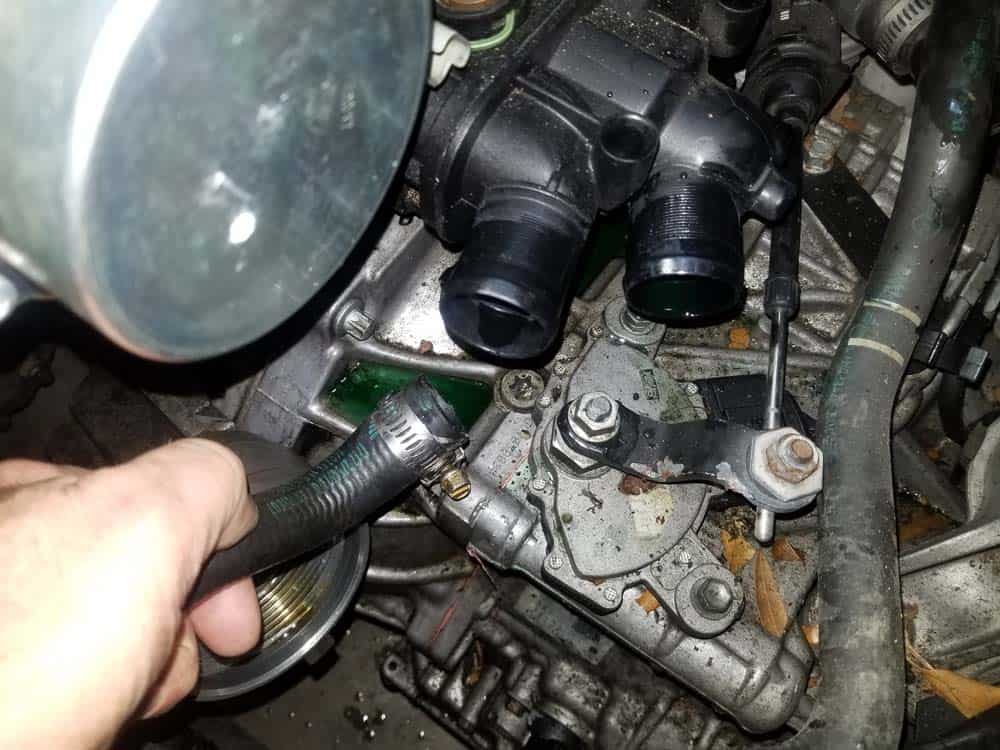 Remove the expansion tank coolant hose from the front of the thermostat.