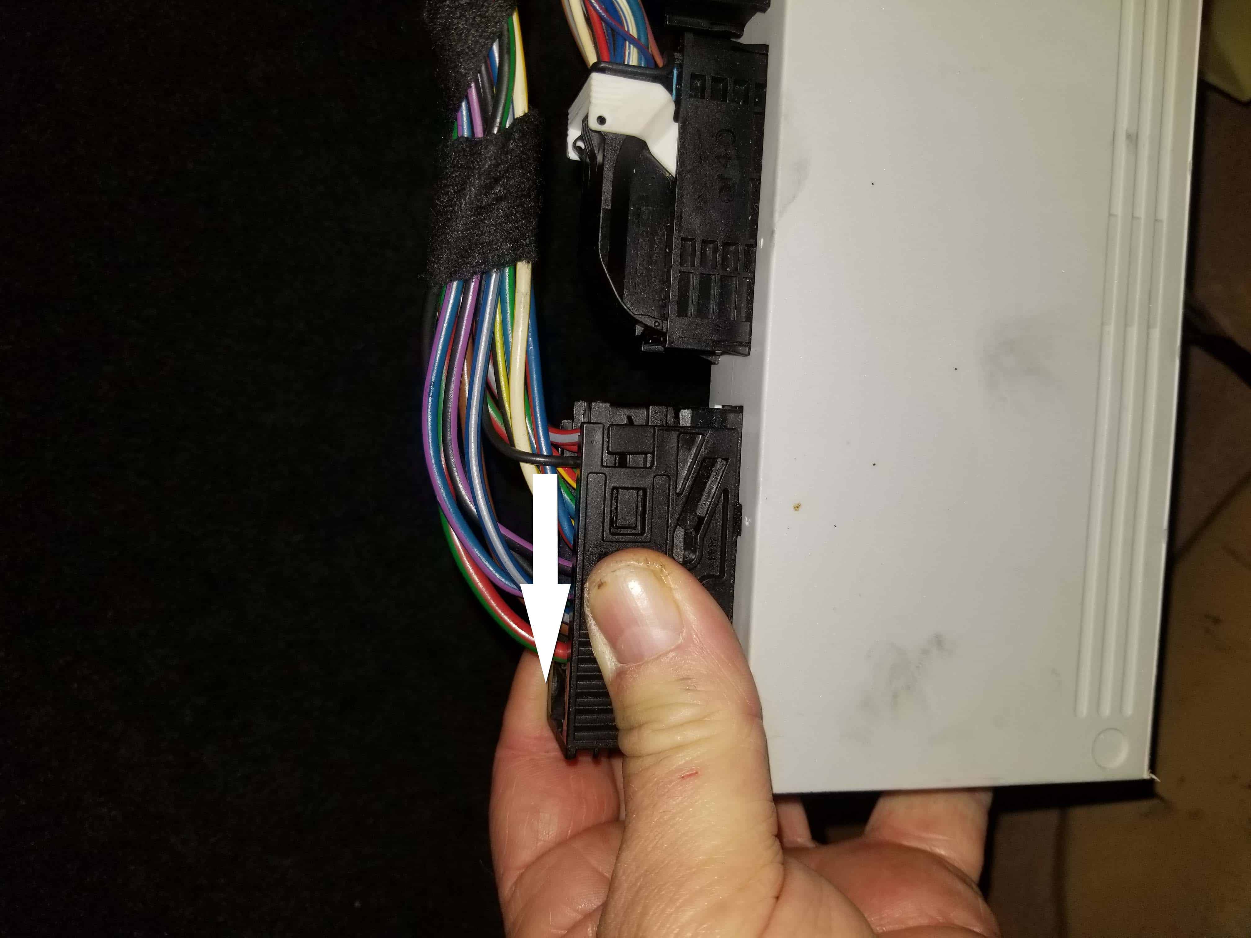 bmw e46 GM5 module - Squeeze the first wiring harness connection and slide it sideways to release it.