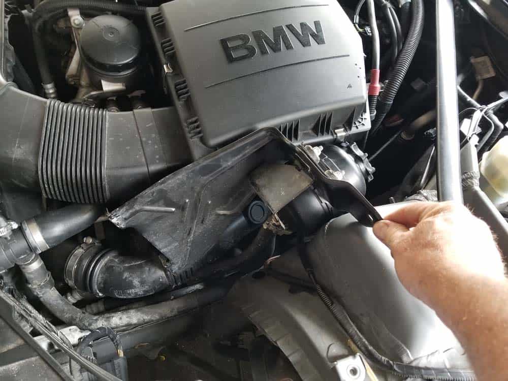 Gently push the power steering reservoir out of the way