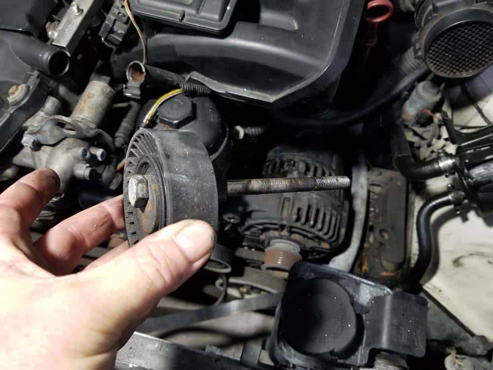 Remove the top mounting bolt/idler pulley from the vehicle