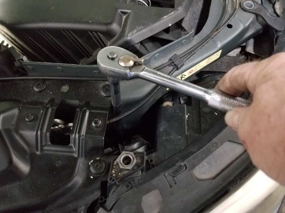 bmw e60 xenon headlight bulb - Use an 8mm socket wrench to loosen the inside lower mounting screw