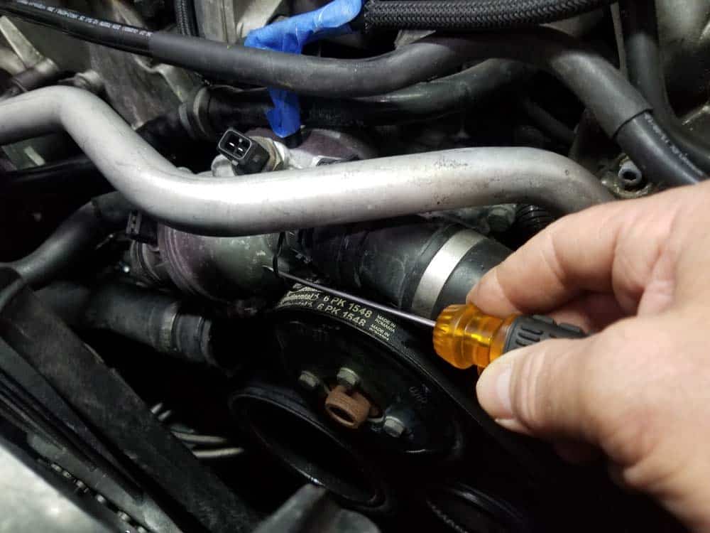 bmw water pump replacement - Release the locking clip on the radiator coolant return hose