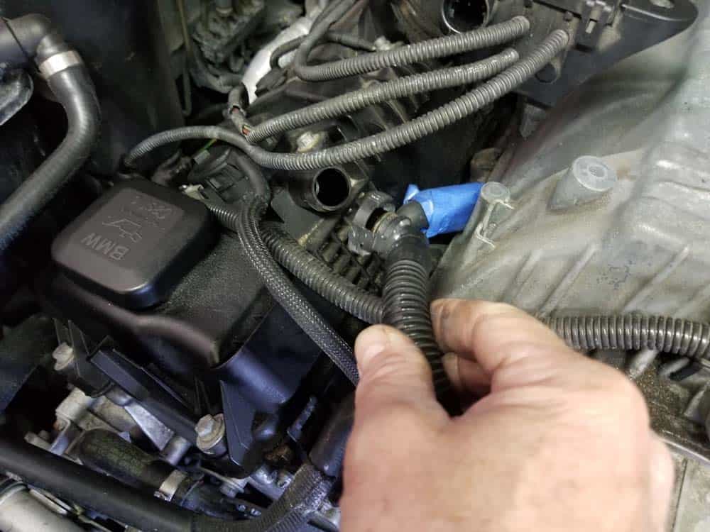 Disconnect the right crankcase vacuum hose from the valve cover.