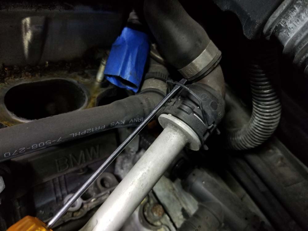 Release the metal locking clip on the heater return line