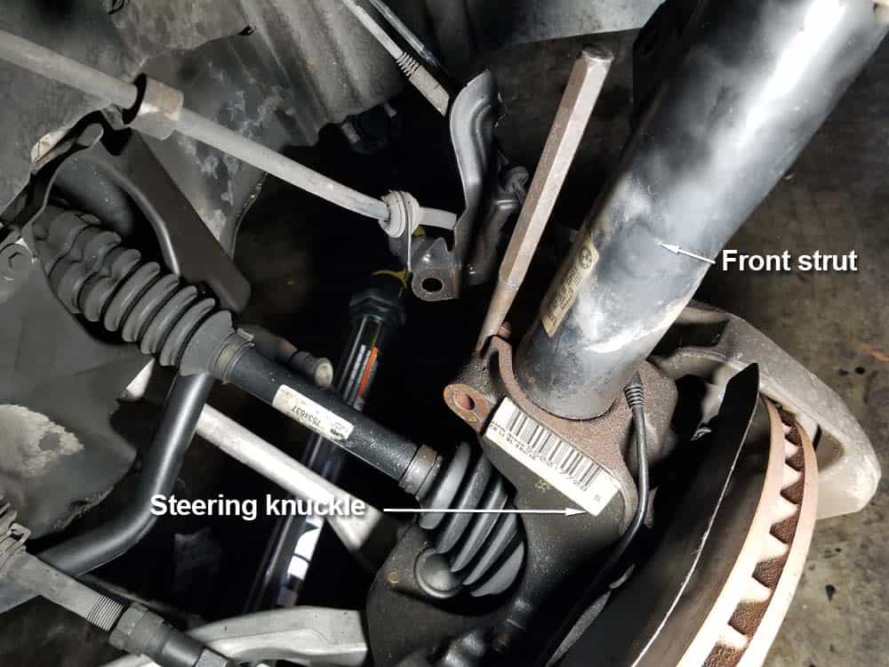 Use a steel punch to spread the steering knuckle open if the strut is seized inside of it.