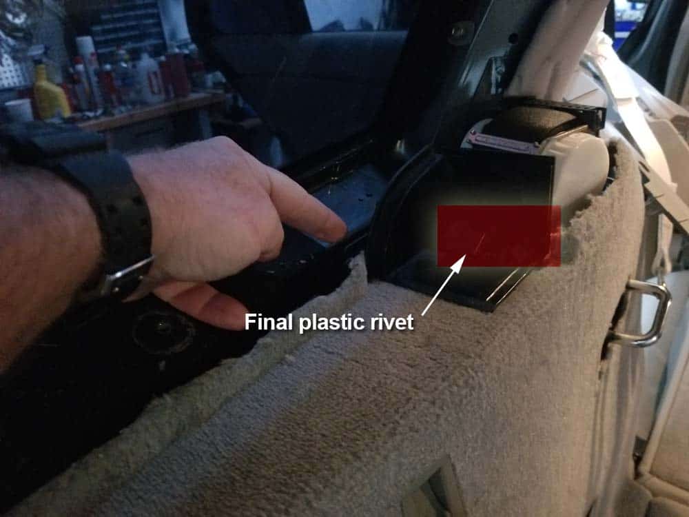 Locate the final plastic rivet securing the lateral trim