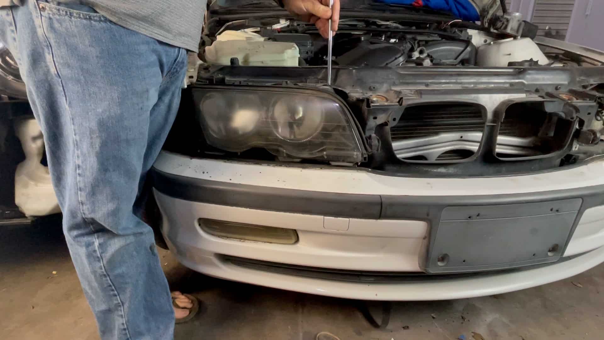 bmw e46 headlight removal - remove the first lower mounting screw with an 8mm socket wrench
