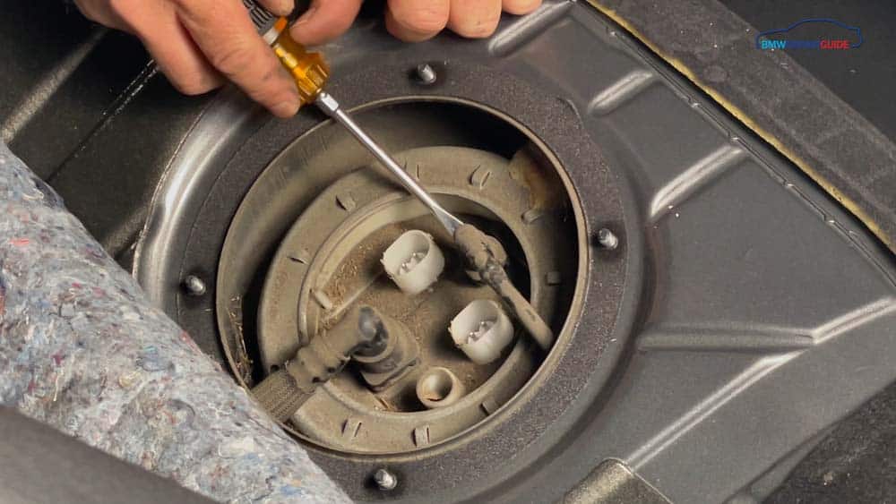 Depress the release with a flat blade screwdriver on the fuel vent pipe